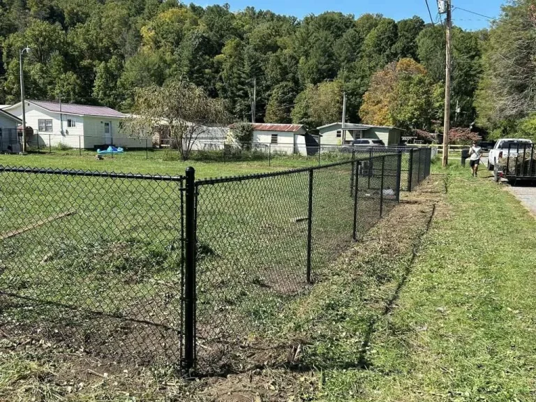 Black chain-link fence installed around a lush green yard in Johnson City, TN.